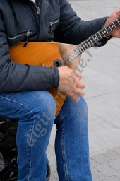 Уличный музыкант играет на балалайке