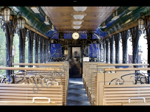Вагон ретро поезда вид изнутри с деревянными скамейками.