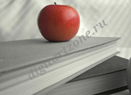 Большое красное яблоко на сером фоне книг.